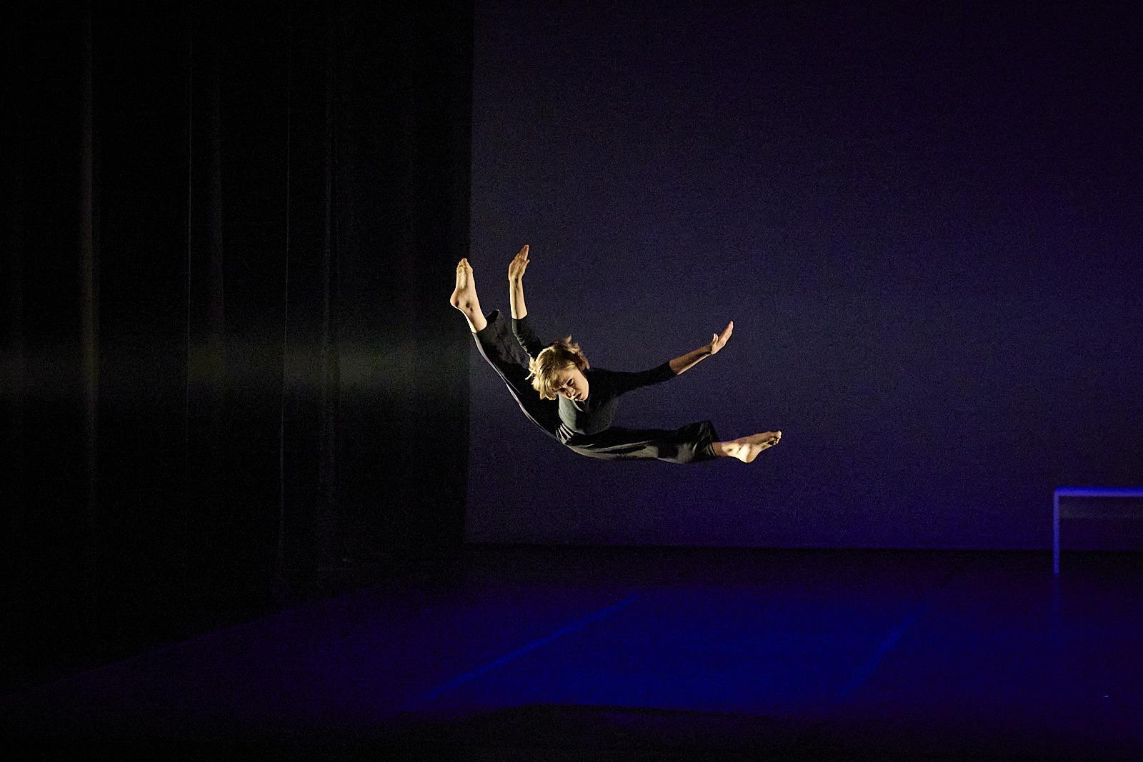 Espetáculo Be Artist — salto suspenso em palco azul